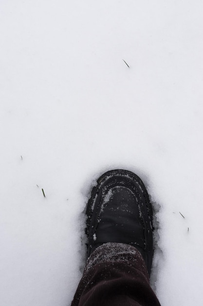 Mannelijke voet die in verse sneeuw stapt