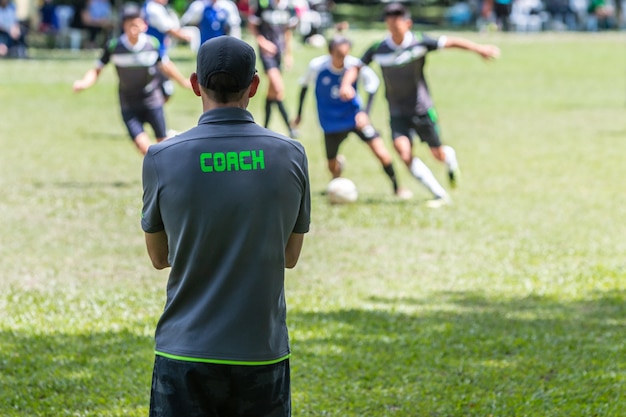 Mannelijke voetbal of voetbalbus die zich op de zijlijn bevinden die op zijn teamspel letten