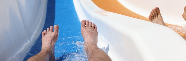 Mannelijke voeten op glijbaan in een waterpark tijdens het afdalen