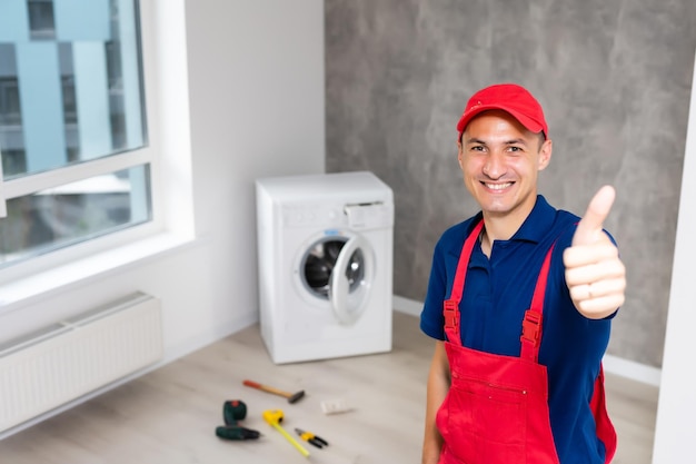 mannelijke volwassen reparateur met gereedschap en klembord wasmachine in badkamer controleren