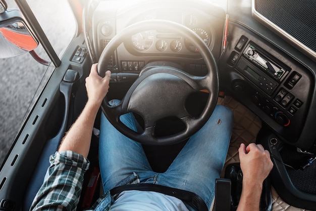 Mannelijke vrachtwagenchauffeur die zijn grote voertuig bestuurt Stuurwiel en dashboard van vrachtwagen