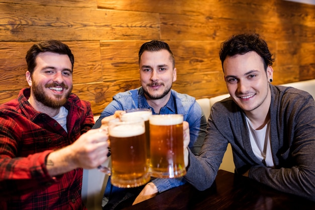 Mannelijke vrienden die bier roosteren bij restaurant