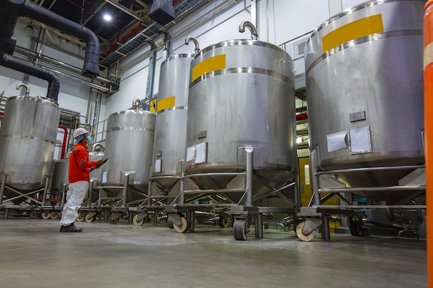 Mannelijke werkinspectie verticale roestvrijstalen tanks fabrieksuitrusting tank chemische kelder bij de met scrollwiel roestvrijstalen tanks mengtank bij controlekamerfabriek