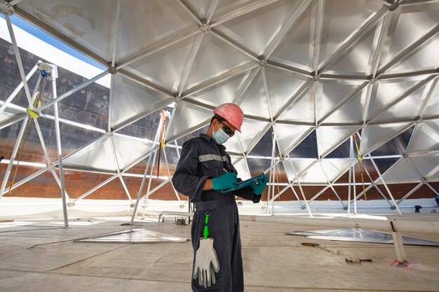 Mannelijke werknemer dossier record visuele inspectie tank in de besloten ruimte is de verlichting dakkoepel aluminium besloten ruimte.