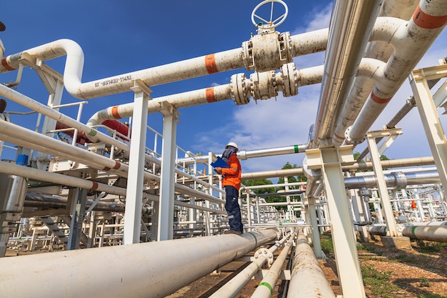 Mannelijke werknemer inspectie bij klep van visuele controle record pijpleiding olie en gas