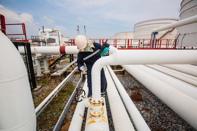 Mannelijke werknemer inspectie en meting dikte pijpleiding olie en gas bij controle record pijpleiding olie- en gasindustrie.
