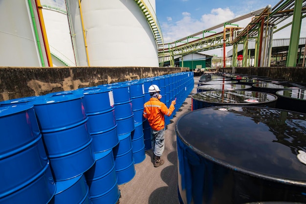 Mannelijke werknemer inspectie record trommel olievoorraad vaten blauw horizontaal of chemisch op een gezichtsmasker