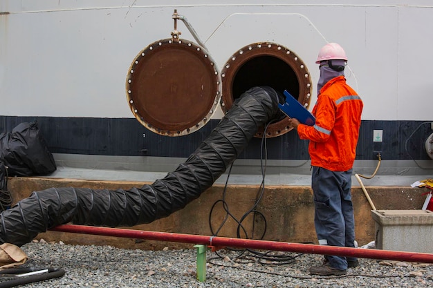 Mannelijke werknemer inspectie van de tank koolstof chemische olie interface beperkt gebied;