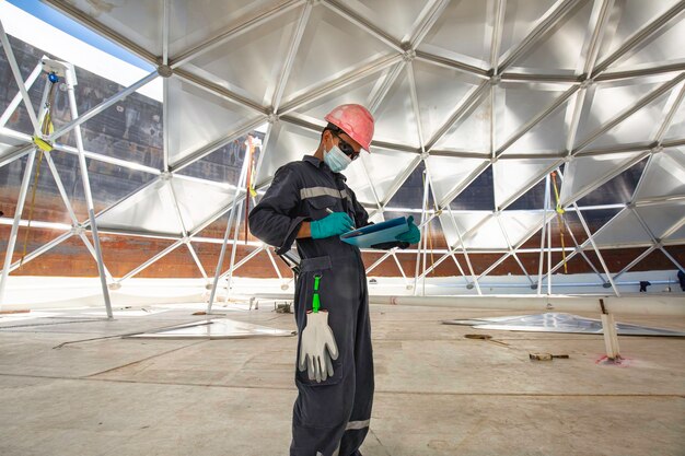 Mannelijke werknemer registreert visuele inspectie tankkoepel aluminium in de besloten ruimte