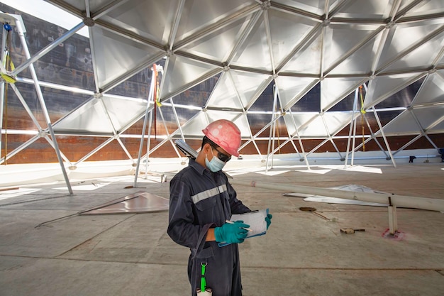 Mannelijke werknemer registreert visuele inspectie tankkoepel aluminium in de besloten ruimte