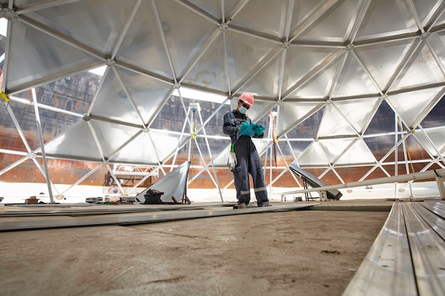 Mannelijke werknemer registreert visuele inspectie tankkoepel aluminium in de besloten ruimte