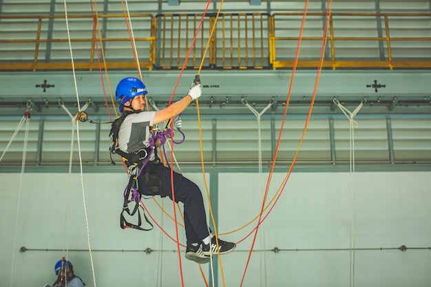 Mannelijke werknemer traint touwtoegang in het werk op hoog niveau