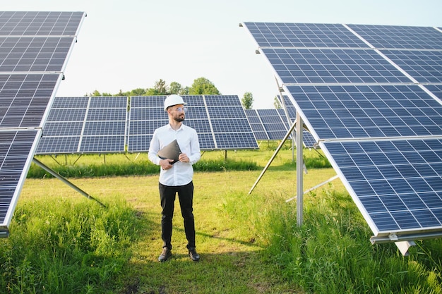 Mannelijke werknemer zonne-energiecentrale op een achtergrond van fotovoltaïsche panelen