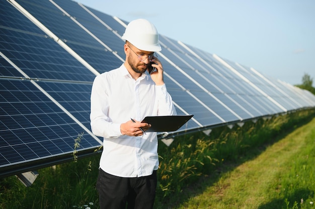 Mannelijke werknemer zonne-energiecentrale op een achtergrond van fotovoltaïsche panelen