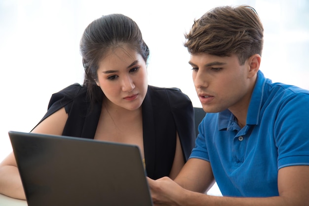 Mannelijke werknemers leren vrouwelijke werknemers computerprogramma's gebruiken in moderne kantoren