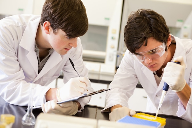 Mannelijke wetenschappers die een experiment in een laboratorium maken