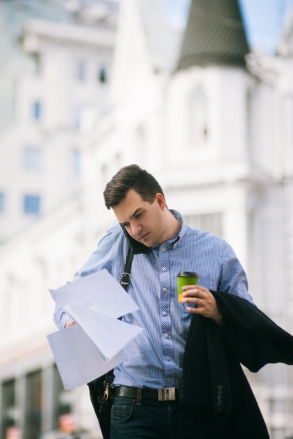 Mannelijke workaholic bij koffiepauze. Drukke man aan het werk op straat