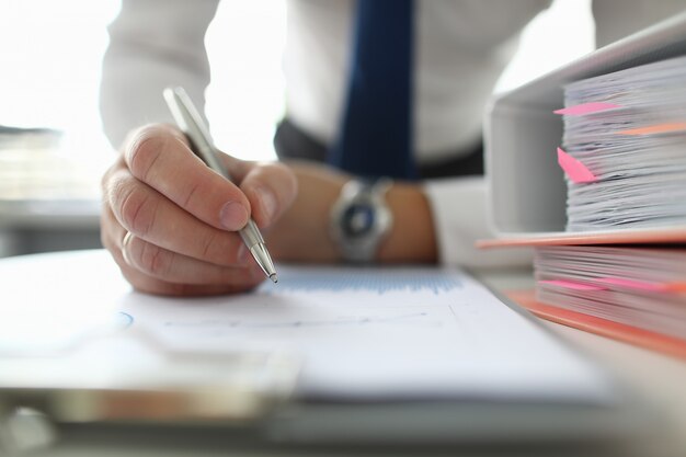 Mannelijke zakenman houden zilveren pen in de hand