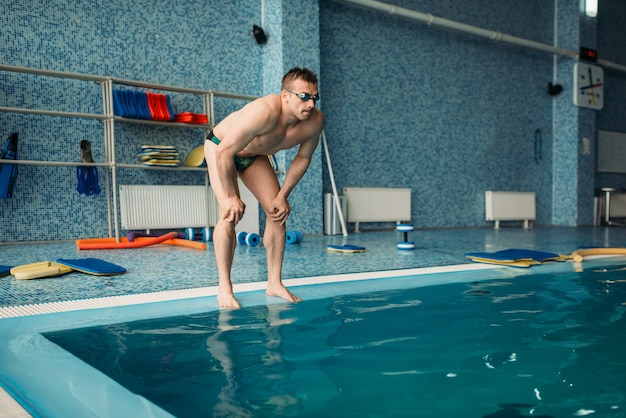 Mannelijke zwemmer bereidt zich voor om in het water te springen