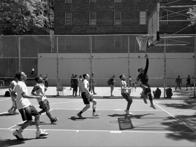 Foto mannen die basketbal spelen op het veld.