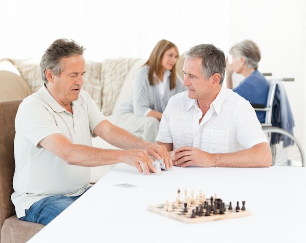 Mannen die kaarten spelen terwijl hun vrouw praat