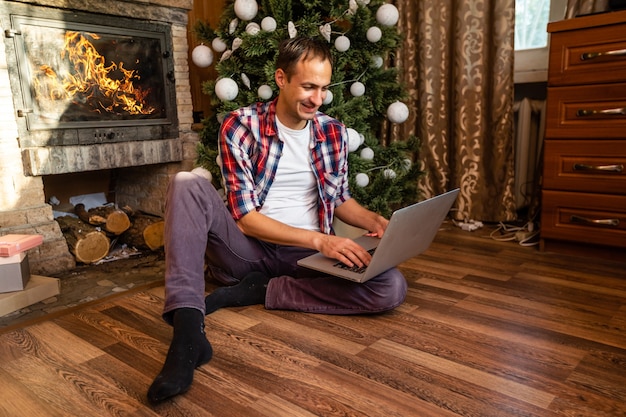 Mannen die laptop gebruiken in een oud houten huis tijdens de kerstvakantie