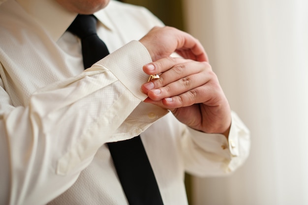 Mannen dragen manchetknopen op een mouw van een shirt