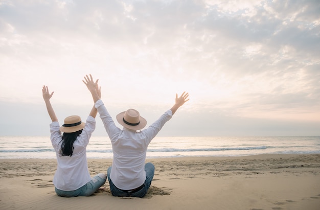 Mannen en vrouwen reizen gelukkig op het strand een ontspannende dag.