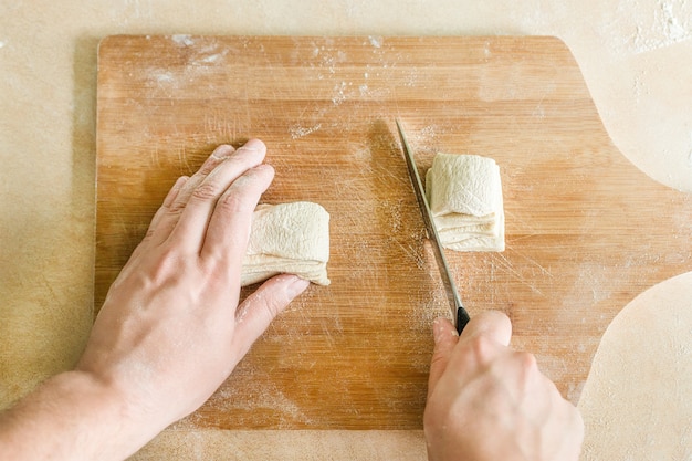 Mannen handen snijden rauw deeg