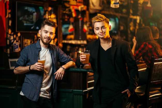 Mannen hieven hun glas met bier in een sportcafé