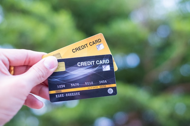 Mannen houden creditcard op bokeh aard