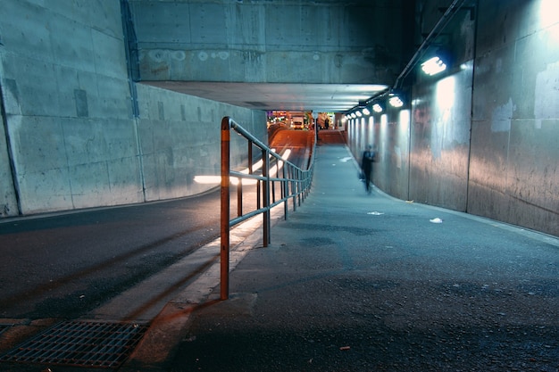 Mannen lopen in de tunnel aan de gang in het donker, Osaka, Japan