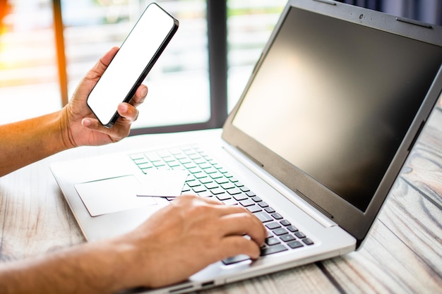 Foto mannen met smartphones met witte schermen en lege zakenlieden die geld overbrengen via het internet