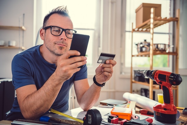 Mannen online winkelen tijdens keukenrenovatie