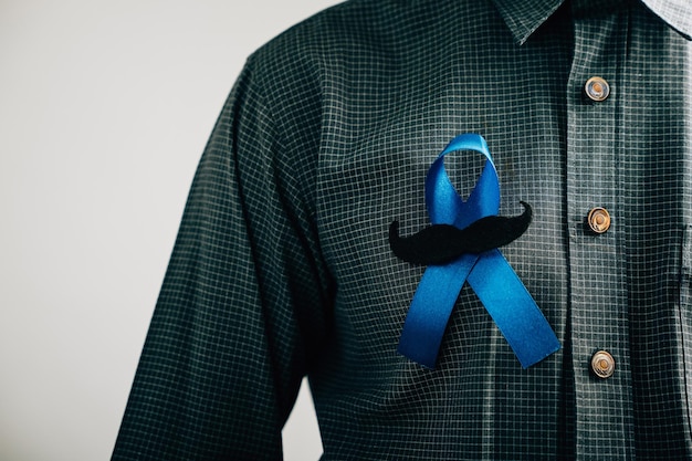 Mannen's handen vertonen een blauw lint met een snor die solidariteit en steun betekent voor dikke darmkanker Colorectal kanker Kindermishandeling bewustwording werelddiabetes dag en Internationale Dag van de Man