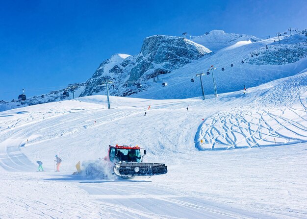 Mannen skiërs en snowboarders op hintertux gletsjer in tirol in mayrhofen, winter alpen. mensen met ski en snowboard bij hintertuxer gletscher in alpine bergen. snowcat-ratrack aan het werk