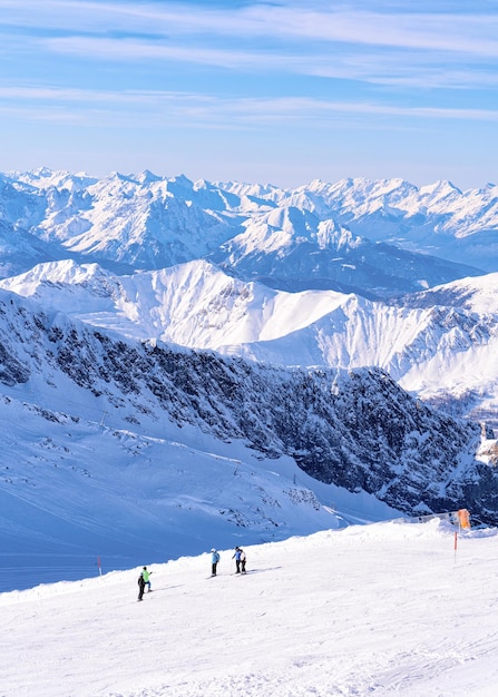 Mannen skiërs skiën in Hintertux gletsjer in Tirol in Mayrhofen van Oostenrijk, winter Alpen. Mensen skiën op Hintertuxer Gletscher in Alpine bergen met witte sneeuw en blauwe lucht. Oostenrijkse besneeuwde hellingen