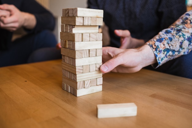 Mannen spelen een spel met houten blokken