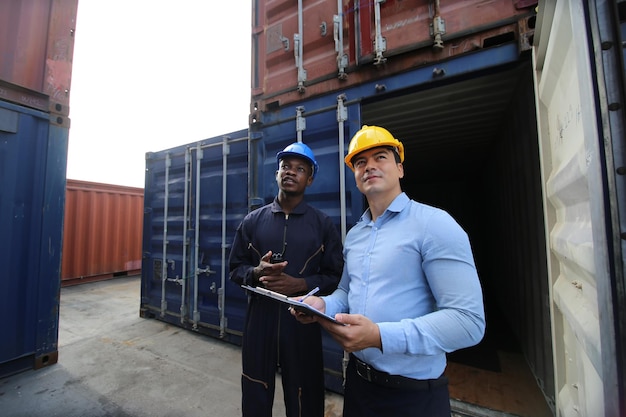 Mannen staan tegen een vrachtcontainer.