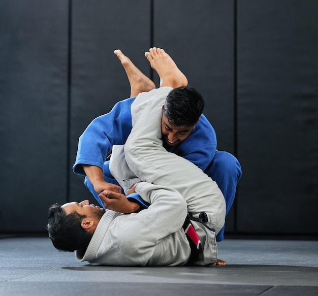 Mannen vechten tijdens karatetraining in de fitnessstudio die vechtclubtraining doen in de sportschool en dojo-bewegingen leren als oefening in het sportcentrum Sterke fitte en stoere mensen die fysieke activiteit doen