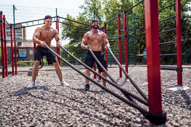 Mannen werken hard met touw op straat gym tuin. Outdoor training. concept van fitness, sport, sporten, training en levensstijl.