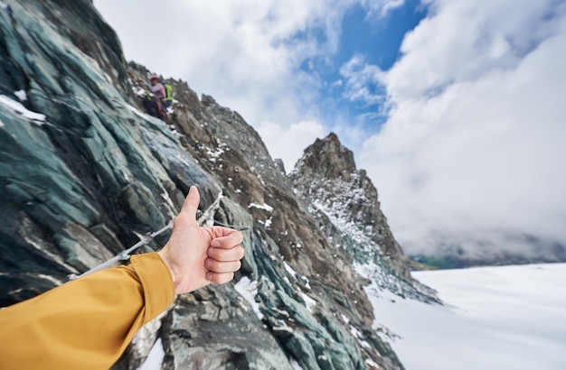 Mannenhand duimen opgevend met bergen op background