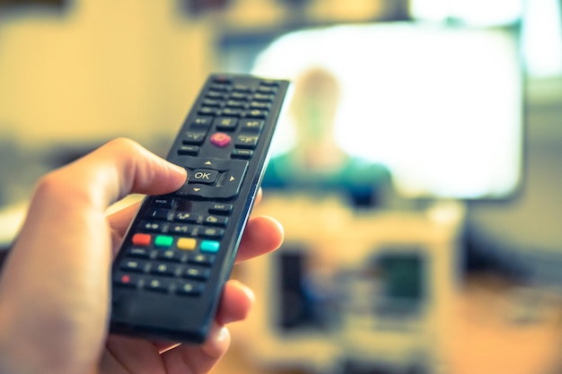 Foto mannenhand houdt tv-afstandsbediening smart tv vast