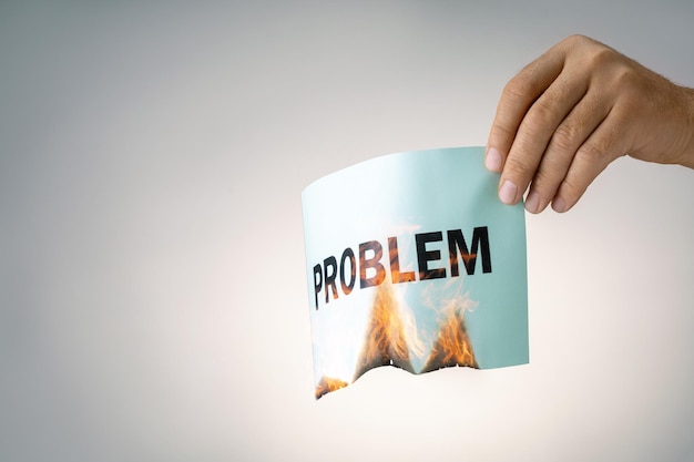 Mannenhand met brandend papier met woord PROBLEEM Concept van oplossing probleem