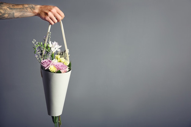 Mannenhand met mooi boeket op donker