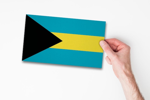 Mannenhand met vlag van Bahama's