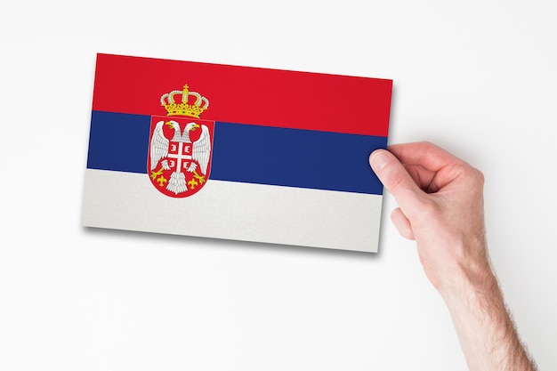 Mannenhand met vlag van Servië