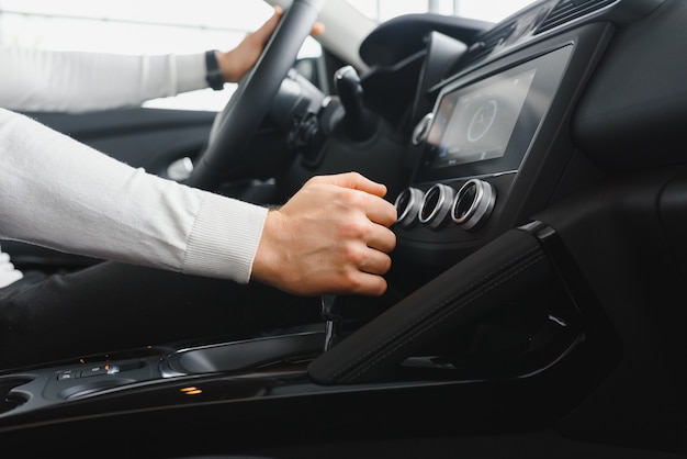 Mannenhand op de schakelhendel van de transmissie in de auto