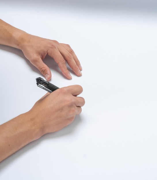 Mannenhand schrijft een zwarte pen op wit papier