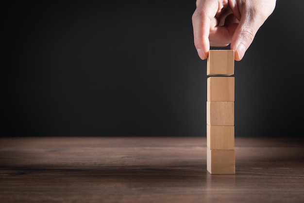 Mannenhand stapelen houten lege kubussen